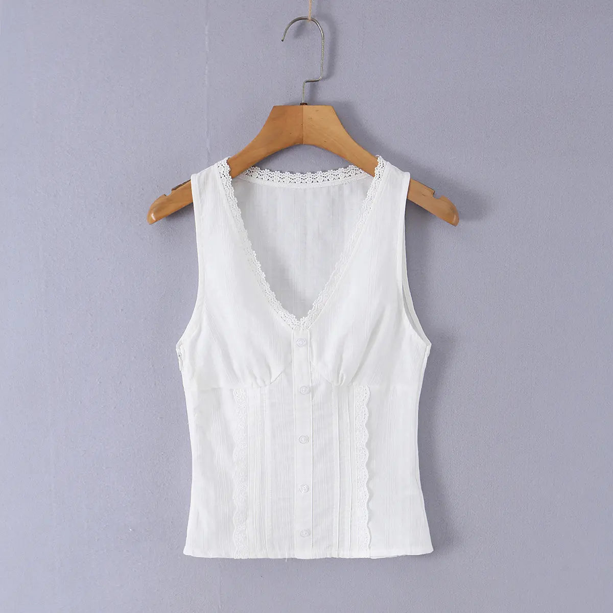 Front view of a white ribbed bustier tank top hung on a wooden hanger, featuring a V-neck with lace trim, front buttons, and a fitted silhouette.