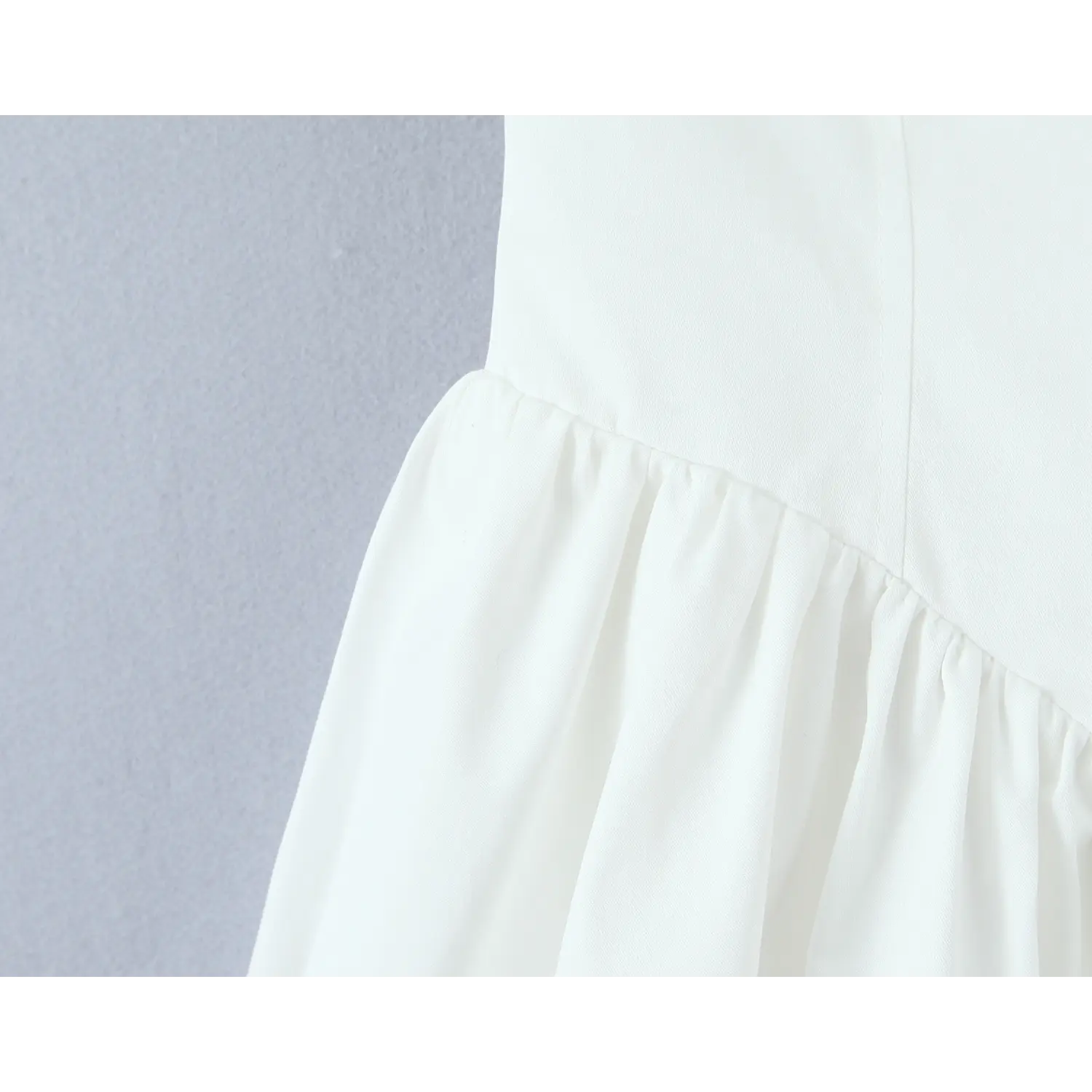 Closeup waist seam view, gathering stitching separating fitted bodice and flared skirt