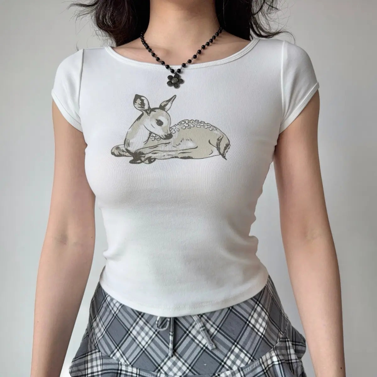 Front view of a white fitted cropped t-shirt with a deer print graphic.