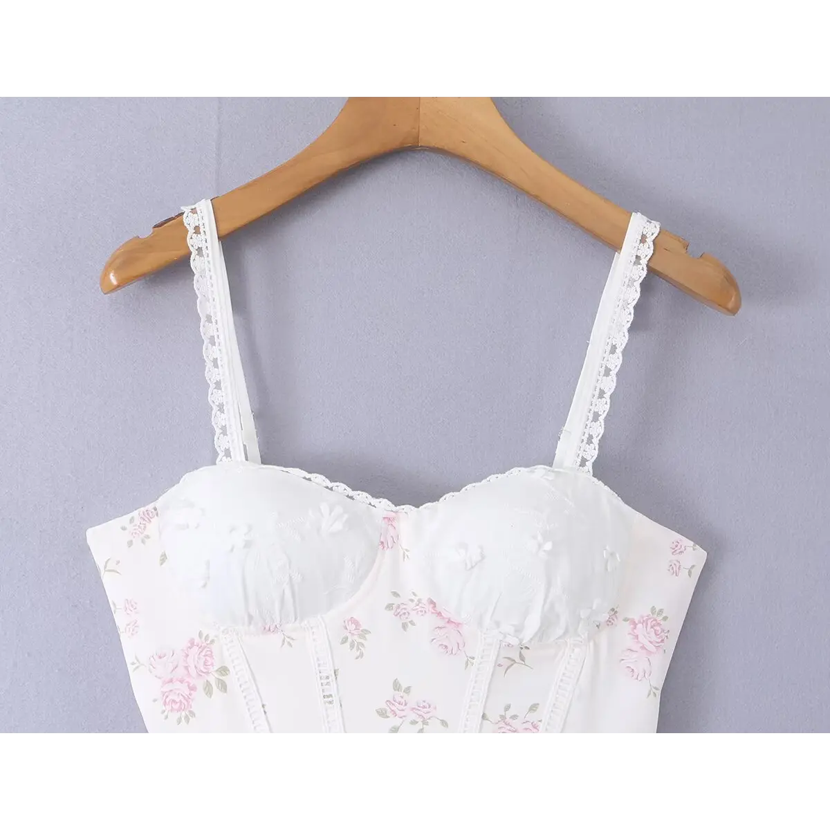 Close-up of the sweetheart neckline, lace trim, and bustier cups on the white floral dress