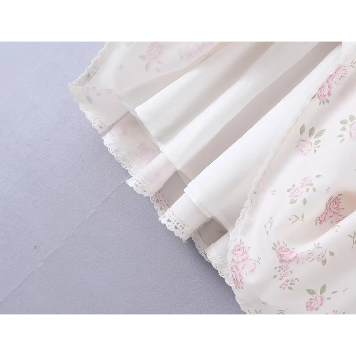 Close-up of the flared skirt hem and inner lining on the white floral print cami dress