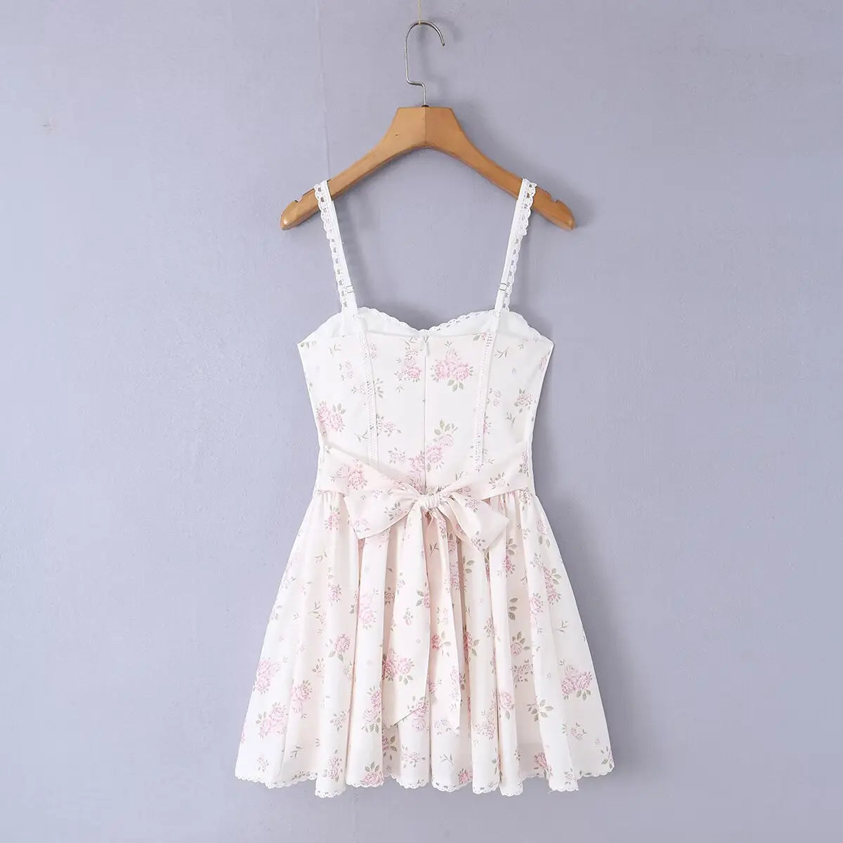 White floral print bustier cami dress hanging on wooden hanger, full back view