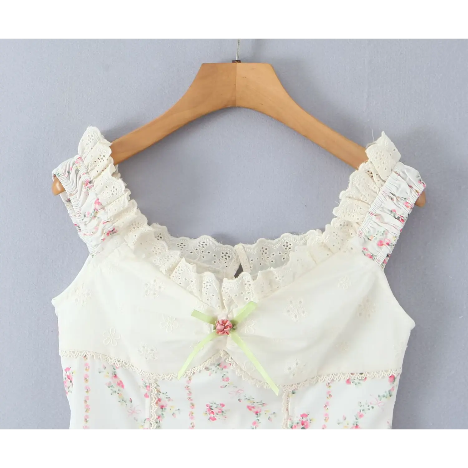 Upper bodice close‑up shot scalloped eyelet lace neckline green ribbon fabric rose ornament ruched bust detail