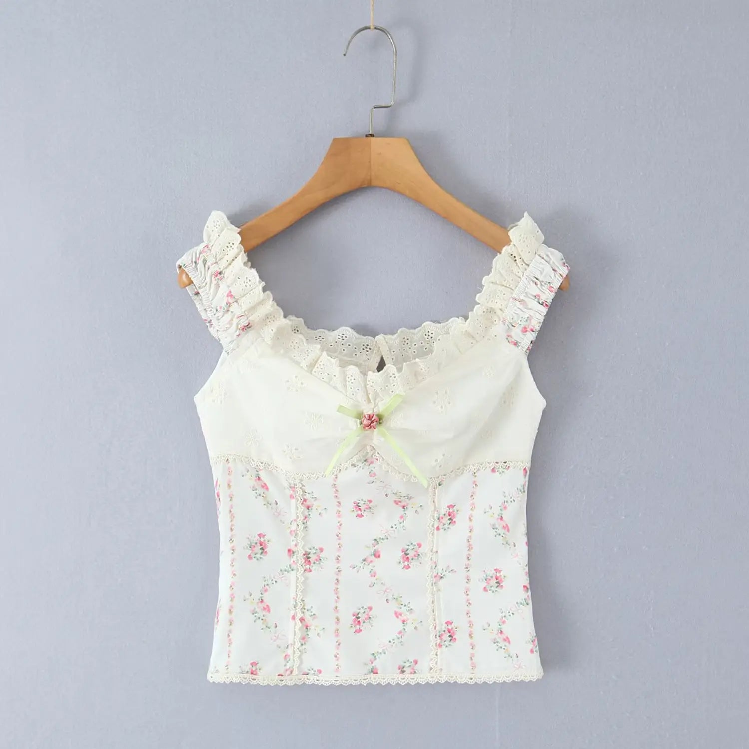 Hanging front view on wooden hanger white floral print corset cami top scalloped eyelet lace neckline