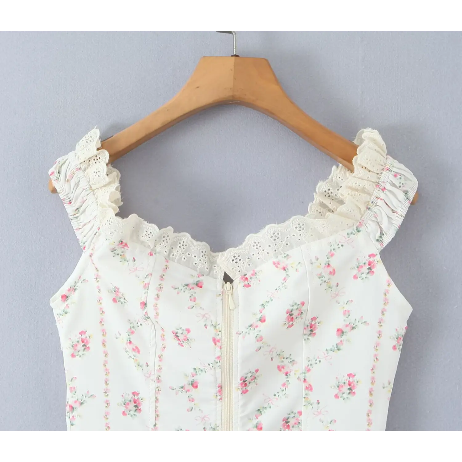 Hanging upper back view white floral corset top eyelet lace ruffle shoulder smocked strap center back zipper