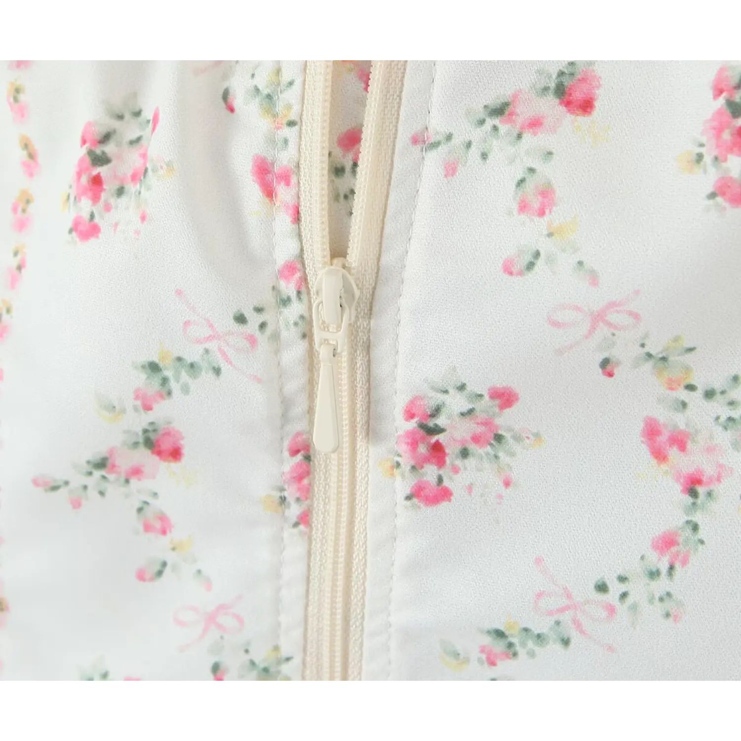 Extreme close‑up back zipper detail white fabric with pink floral and tiny bow print corset top
