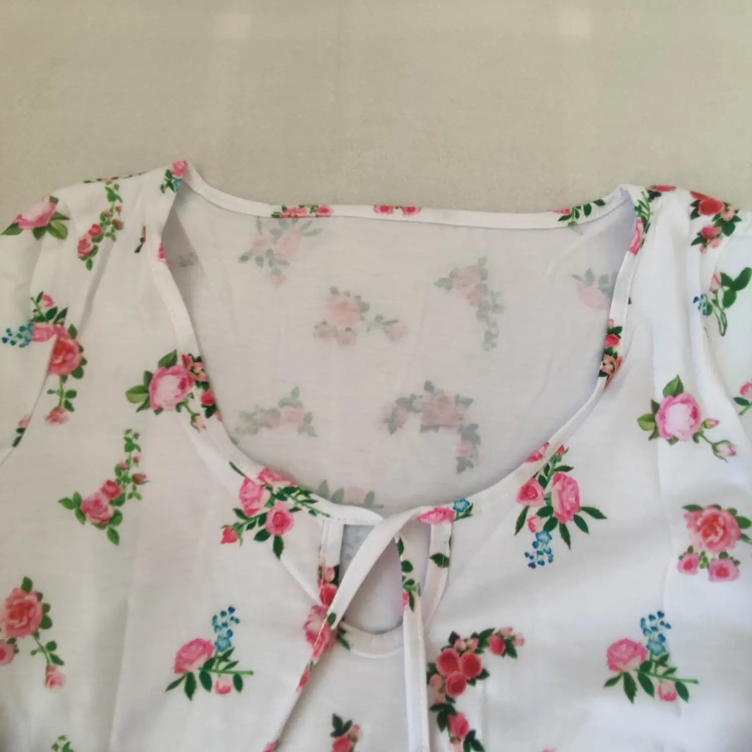 Close‑up neckline keyhole and tie detail white short sleeve rose floral crop top