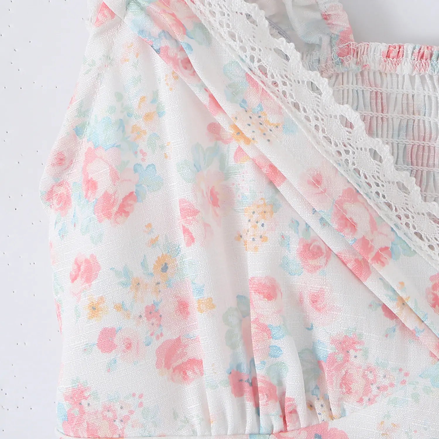 White floral crop top v-neck bust close-up, cross hollow lace trim and front gathered printed fabric