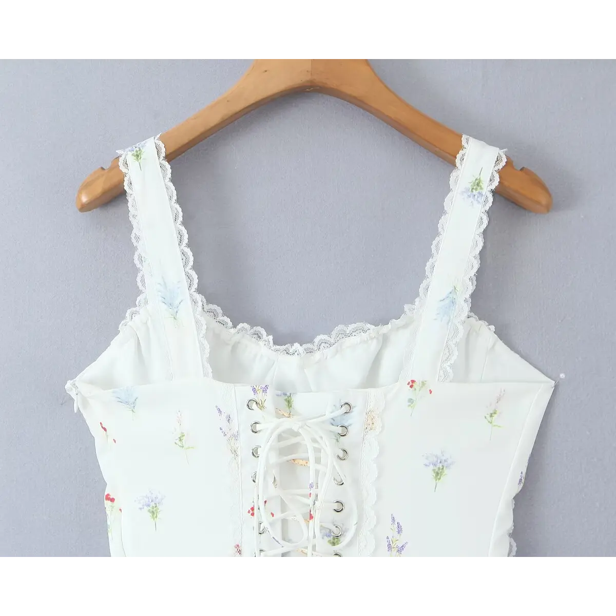 Close-up of the dress's back, showing the lace-up corset closure and lace-trimmed straps.