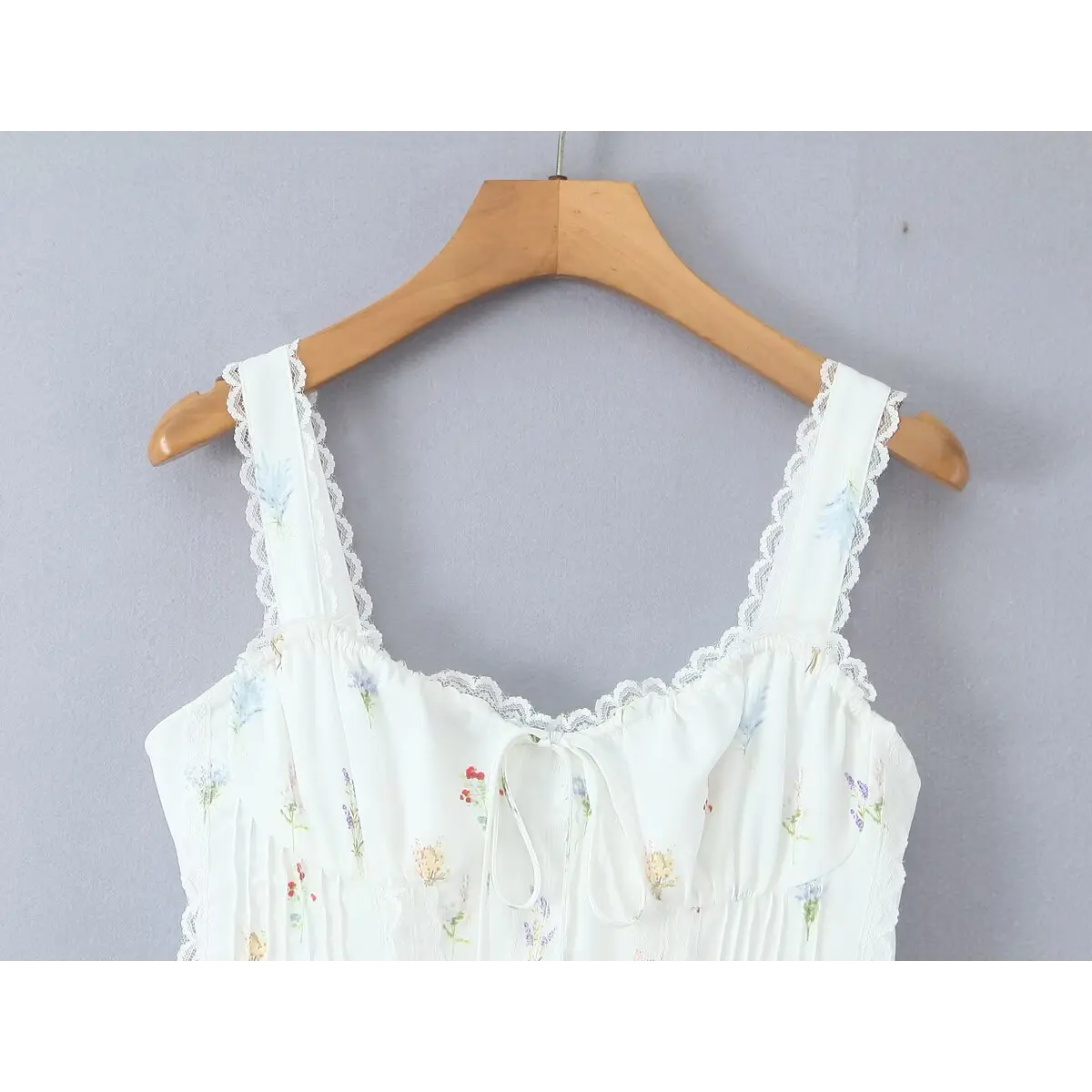 Close-up of the dress's bust area, showing the lace-trimmed straps and keyhole tie detail.