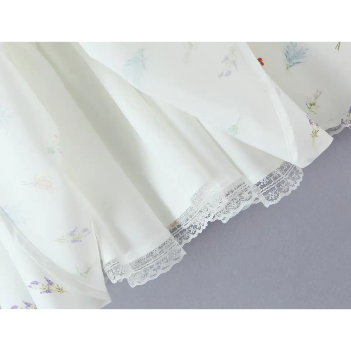 Close-up of the dress's hem, featuring delicate lace trim and layered fabric.
