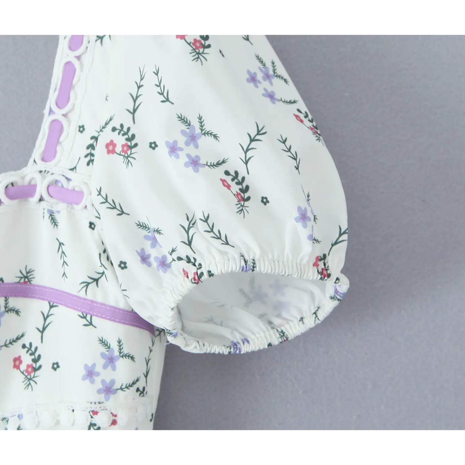 Close‑up of puff short sleeve cuff, elastic gathered hem, white base with purple red ditsy floral print