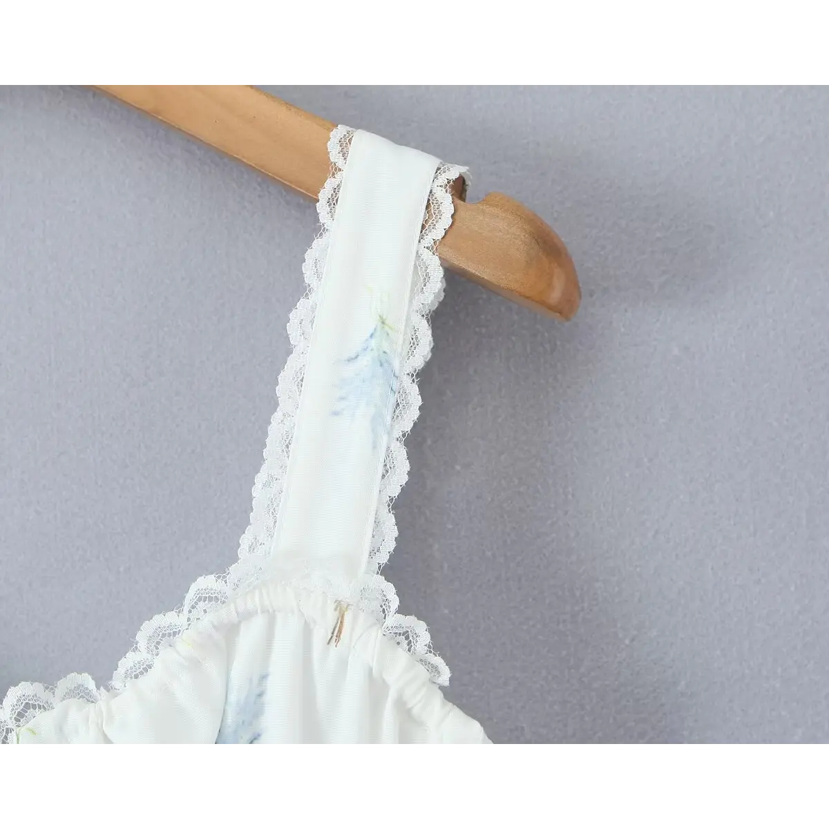Close-up of the dress's strap, showing lace edging and the floral print.