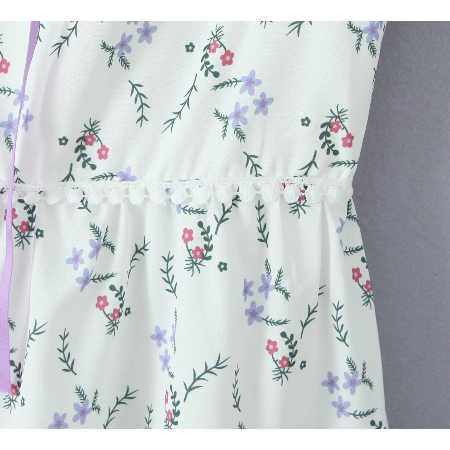 Dress waist close‑up, delicate white lace trim, ditsy wildflower print on lightweight white fabric