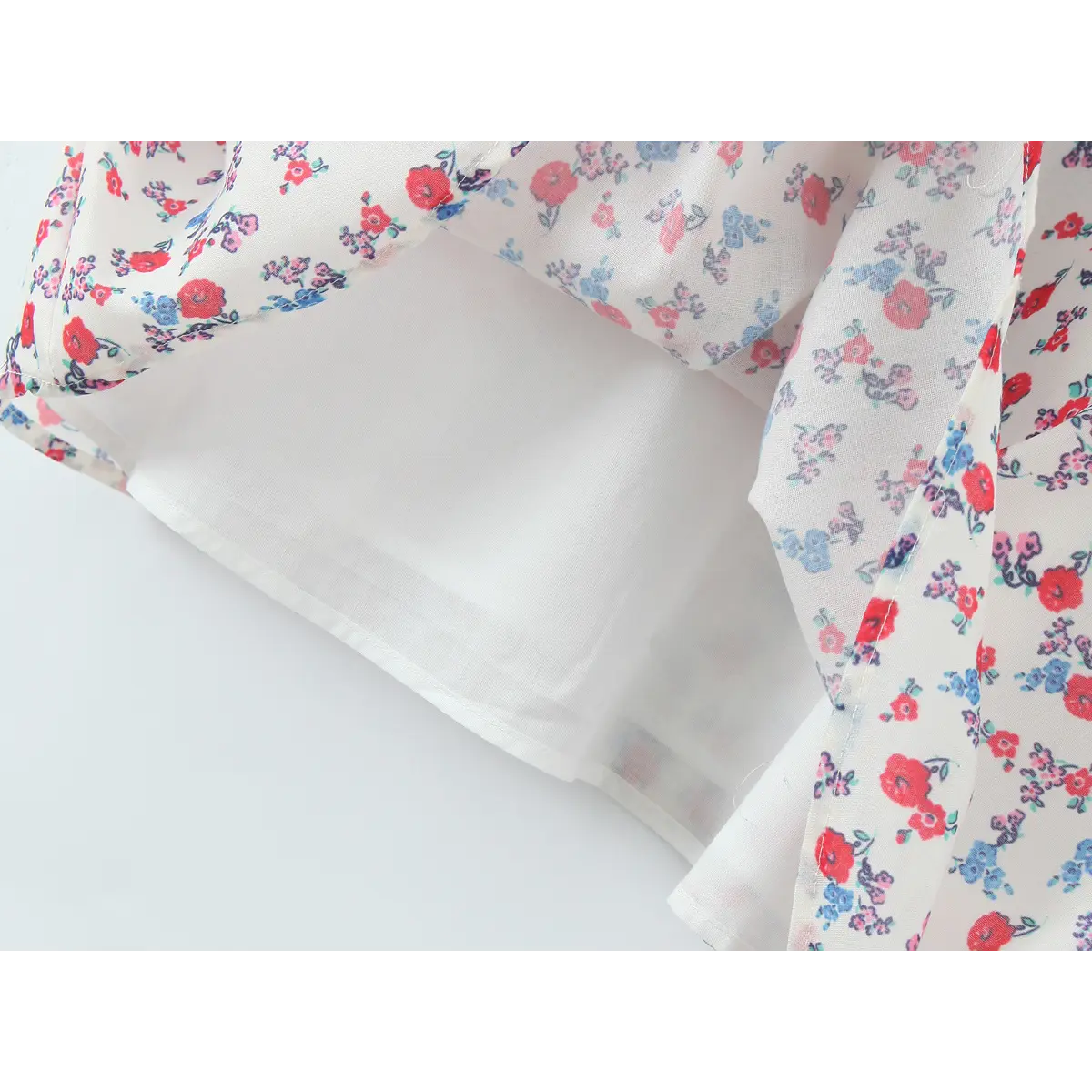 Close-up of the lightweight inner lining visible through the sheer floral print skirt of the slip dress