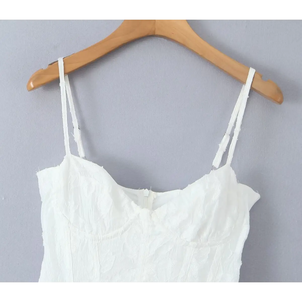 Partial view of the white corset dress showing adjustable straps and boned bodice details