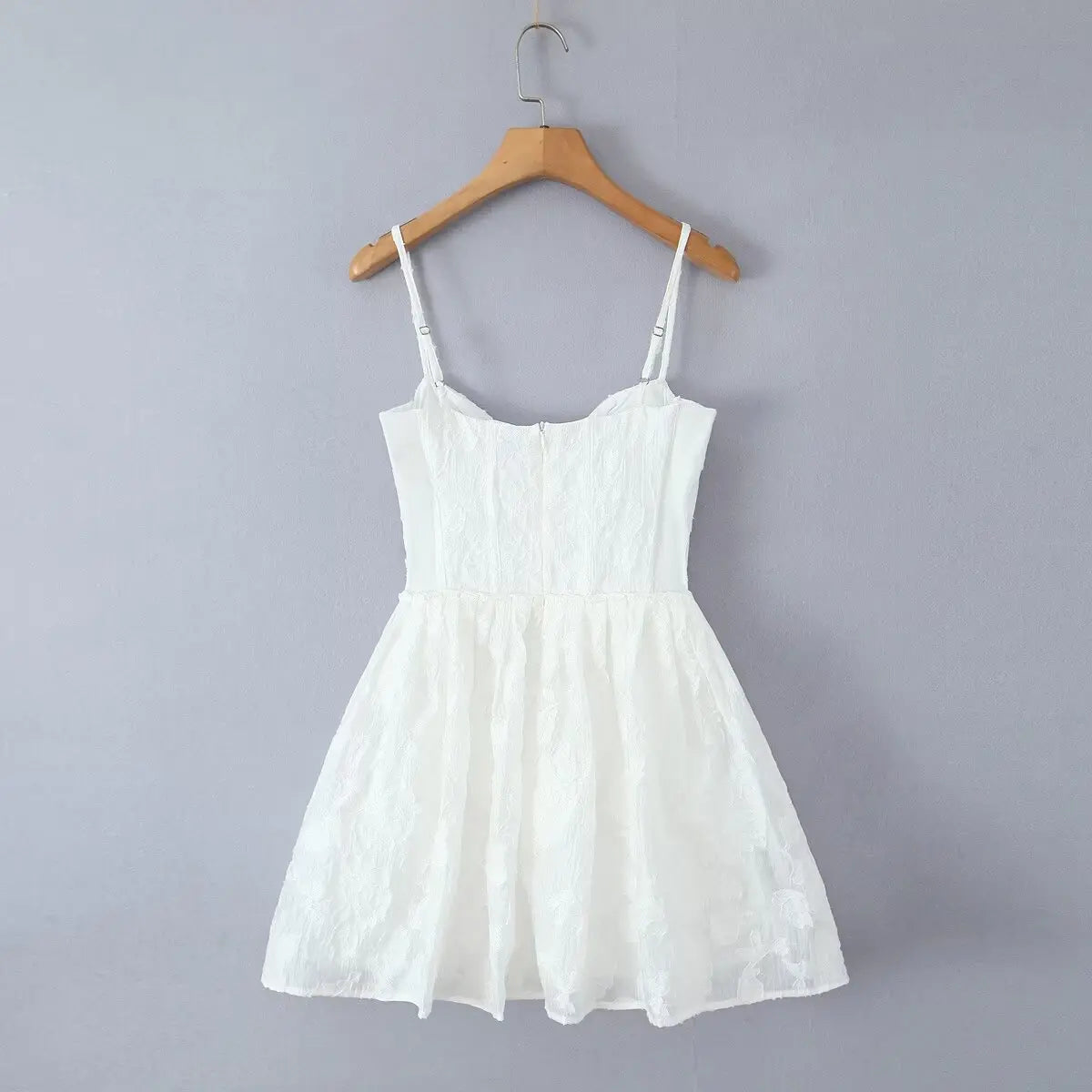  Full back view of white corset-style spaghetti strap mini dress on wooden hanger, showing zipper closure