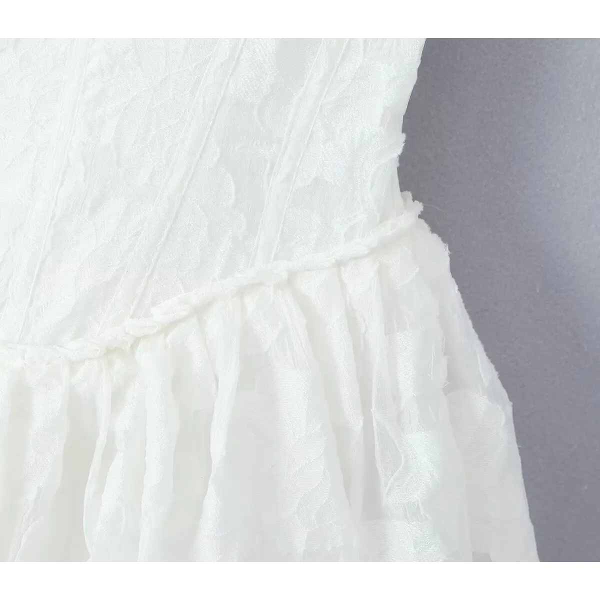 Close-up of the waistline seam connecting the corset bodice to the flared skirt