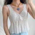 Lifestyle outfit photo of model wearing white lace peplum cami, paired with light blue denim jeans and oversized heart pendant gold chain necklace