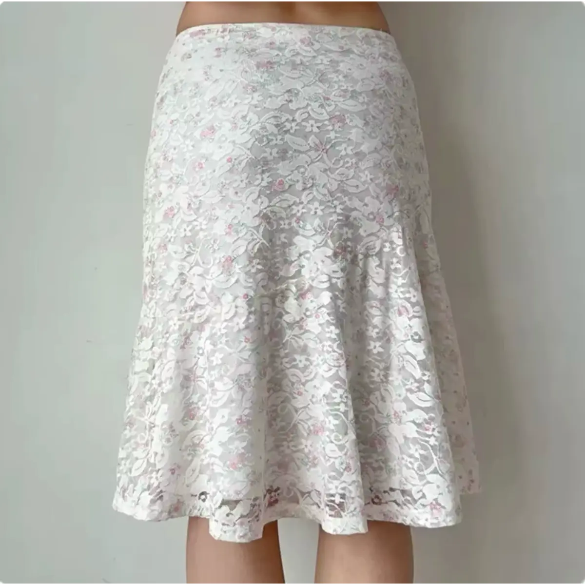 Back view of a white floral lace midi skirt with pink accents.