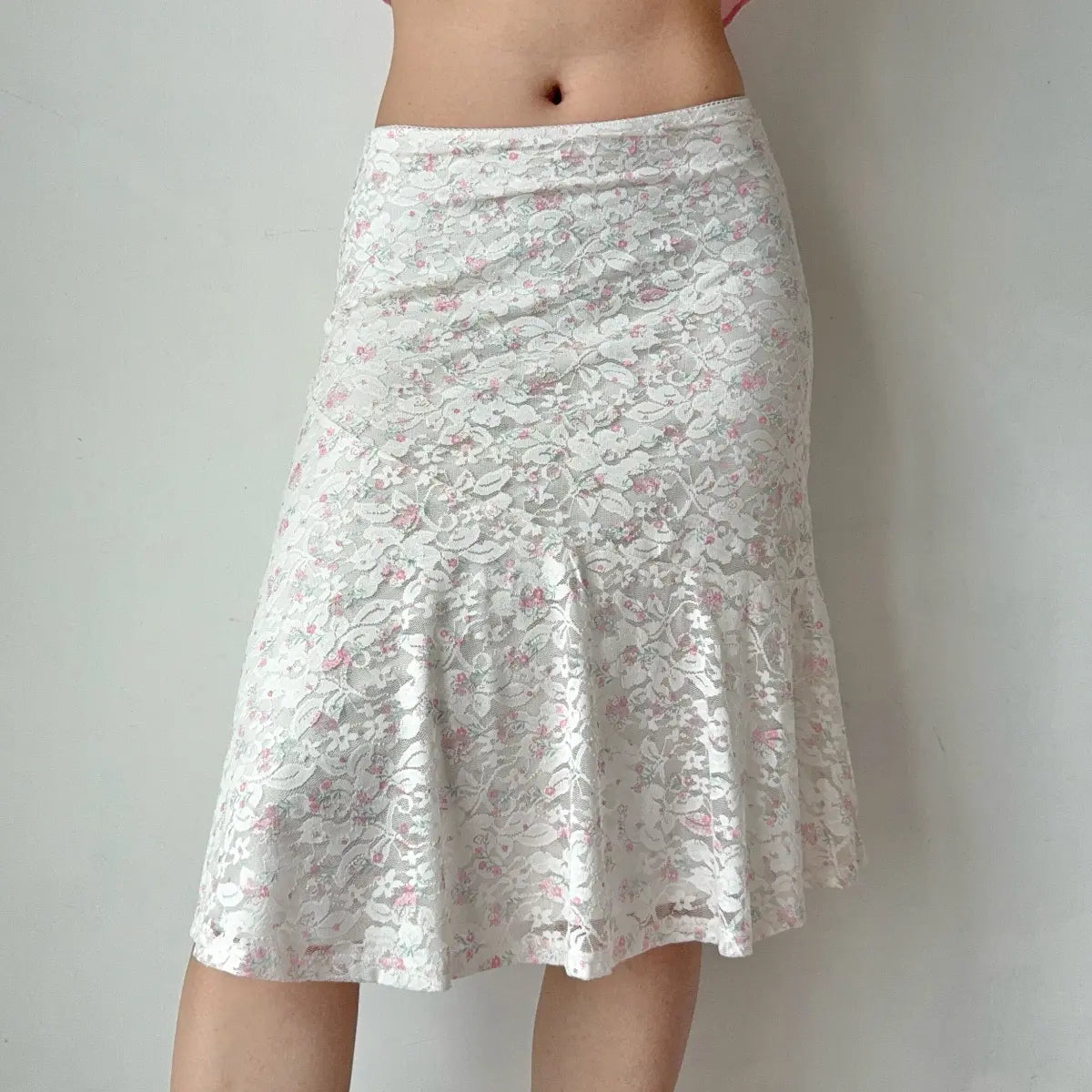 Front view of the white floral lace midi skirt with pink floral embroidery.
