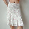 Slight side view of the white floral lace midi skirt, highlighting the flared hem.