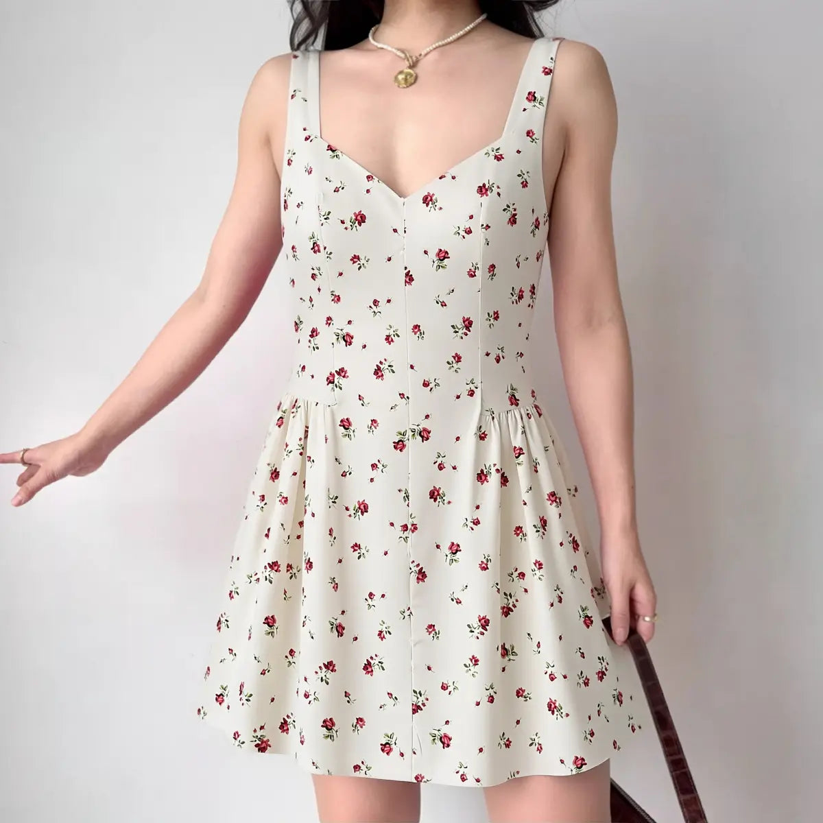 The floral dress styled on a model, highlighting its sweetheart neckline, cinched waist, and flared mini skirt silhouette.