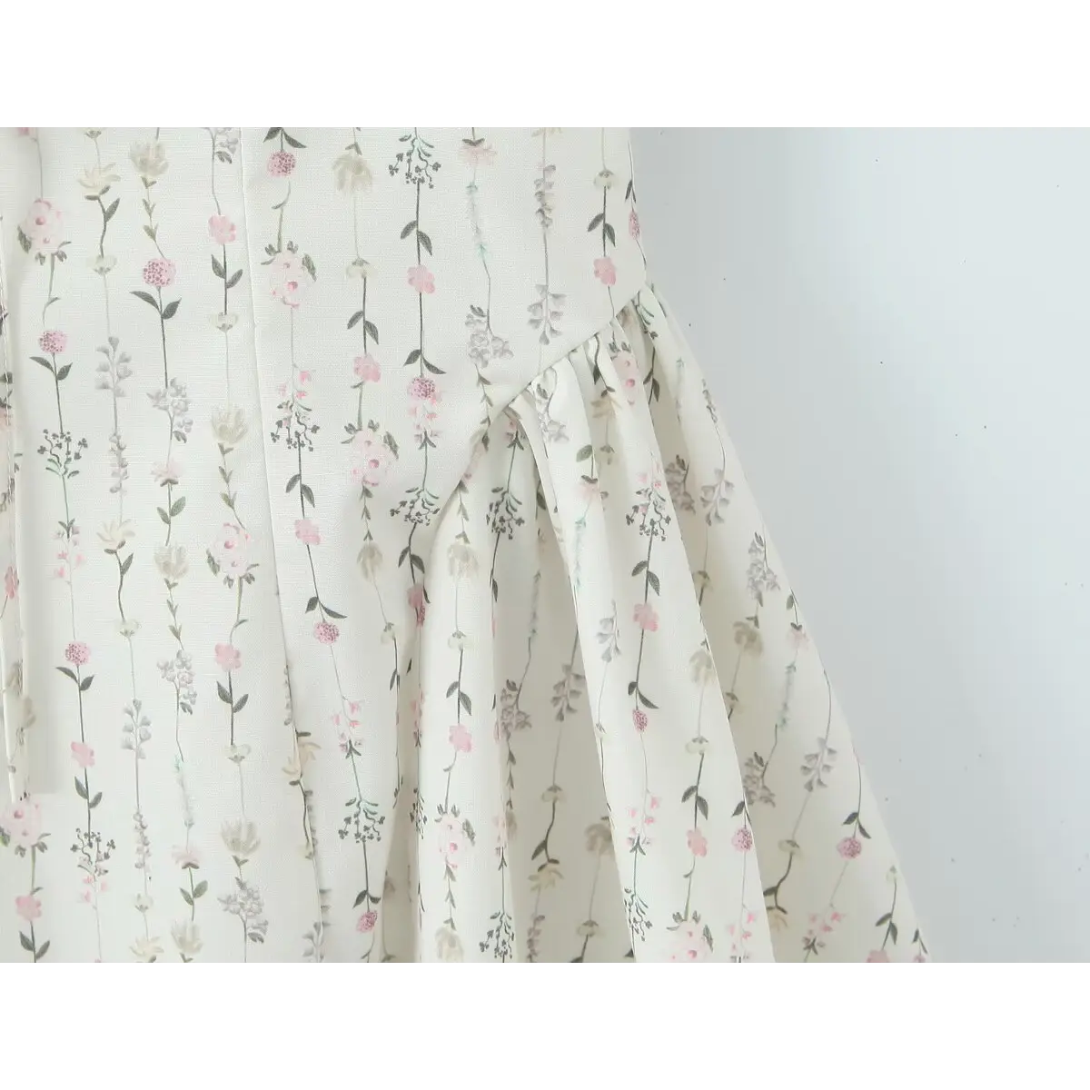 Close-up of the ditsy floral print and fabric texture on the white square-neck cami dress