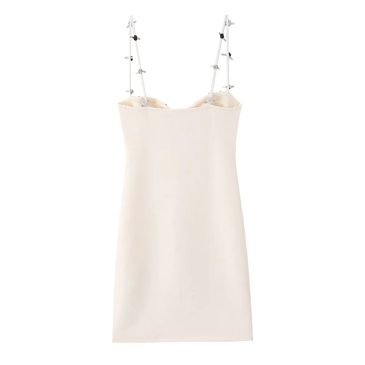  Back view of a form-fitting white mini dress with decorative floral and button details on the straps.