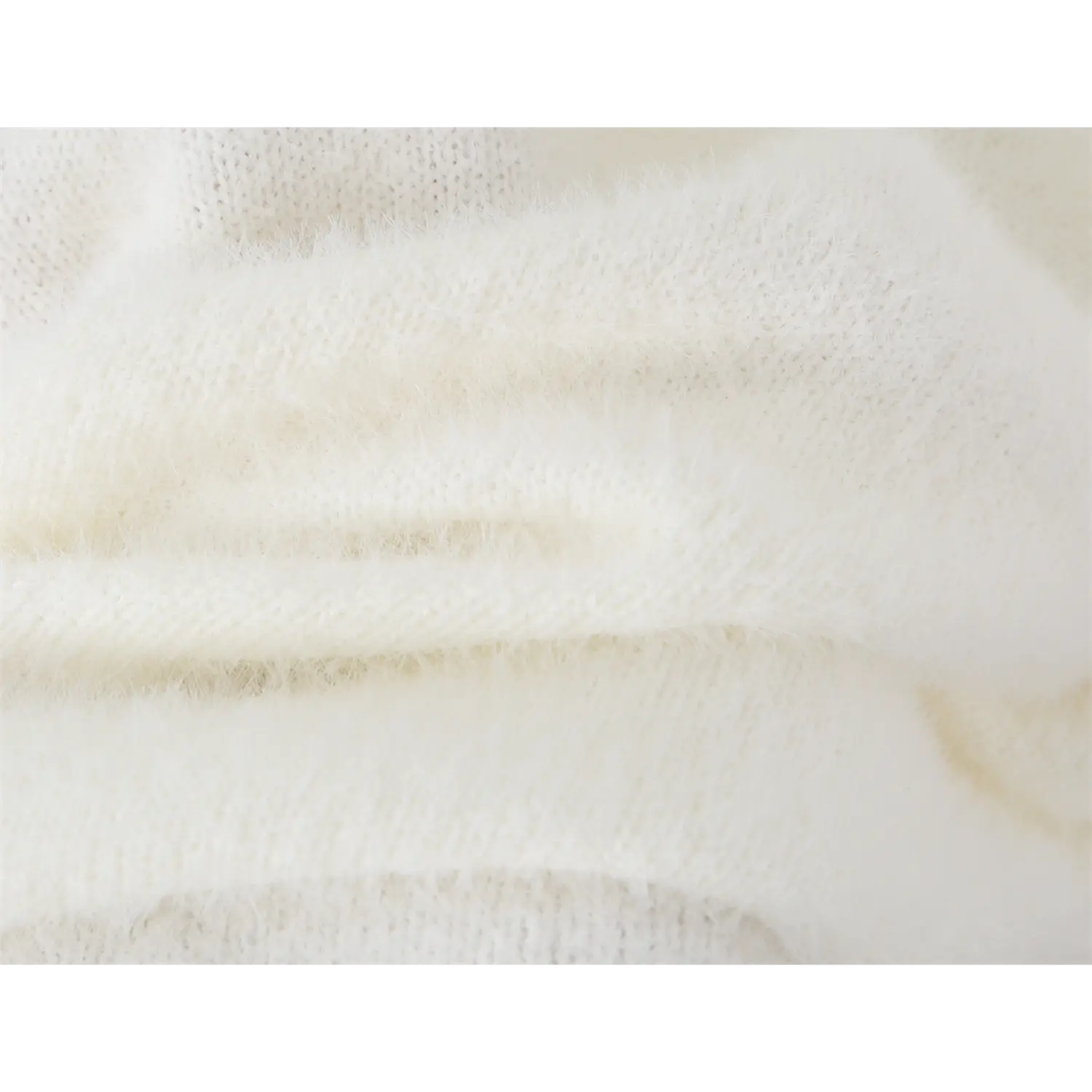 Close-up texture shot of soft white fuzzy knit fabric with fluffy plush surface, lightweight stretch knit material