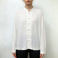Model wearing white mandarin collar frog button shirt with black trousers
