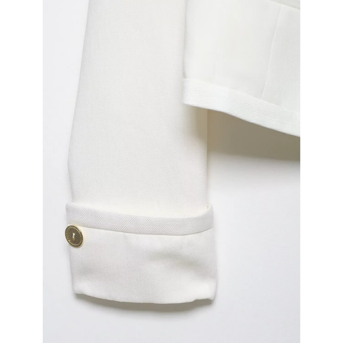 Close-up of folded cuff and gold button