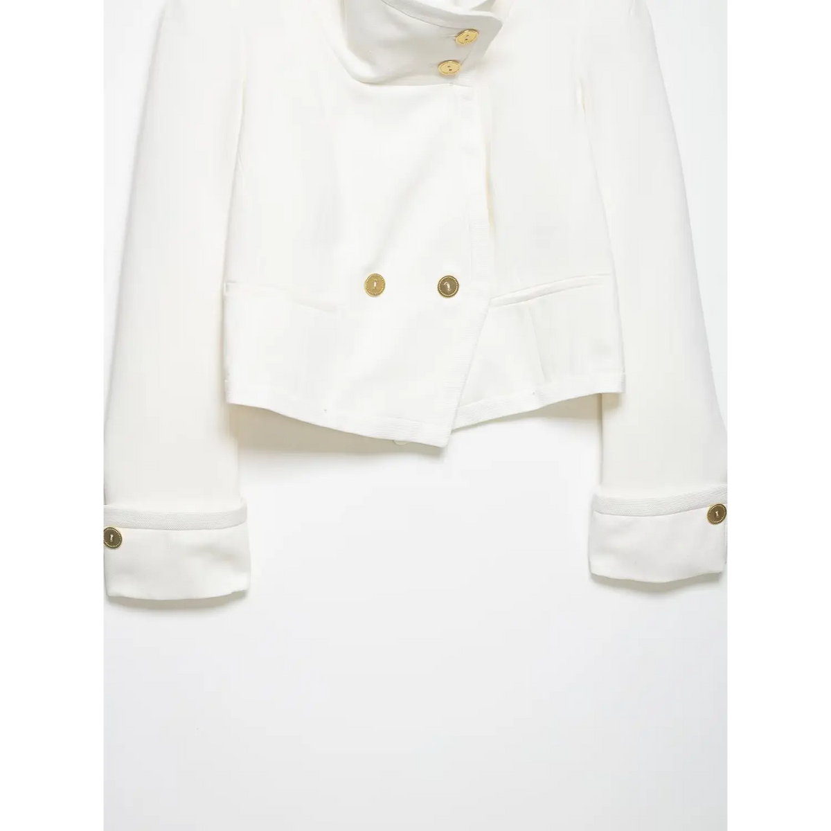 Close-up of gold buttons, pockets and cuffed sleeves