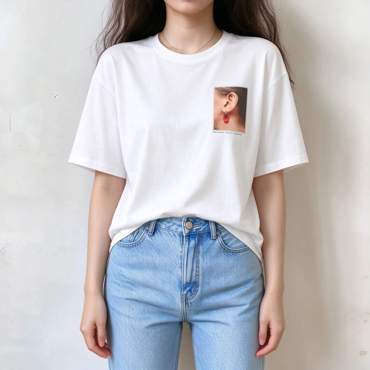 Model wearing white crew neck graphic t-shirt, earring photo print on chest, relaxed fit short sleeve tee, matched with light blue jeans on plain white wall
