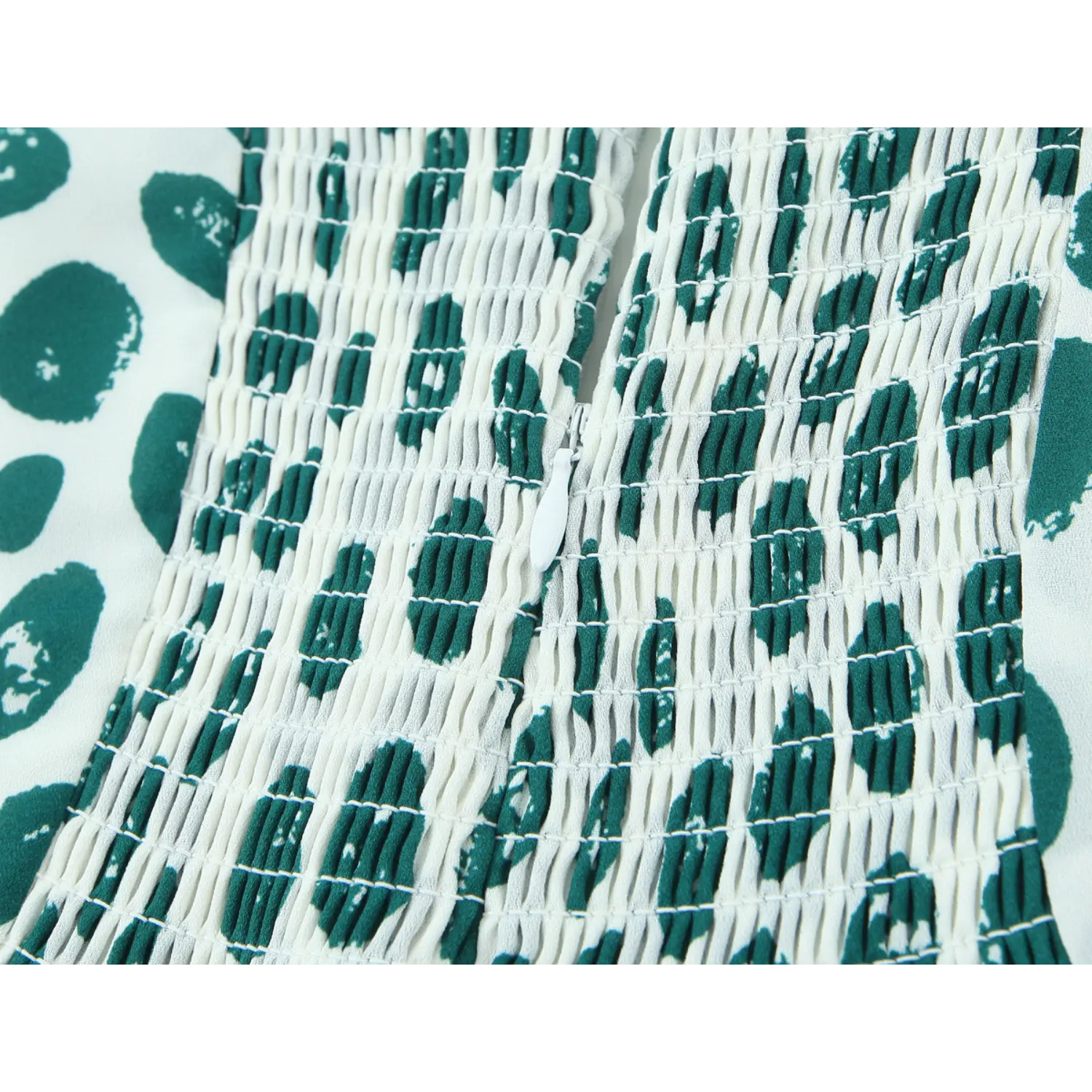 Close-up back shot full elastic smocked panel, hidden invisible side zipper, off-white base dark green hand-drawn irregular dot print, stretch shirred woven fabric