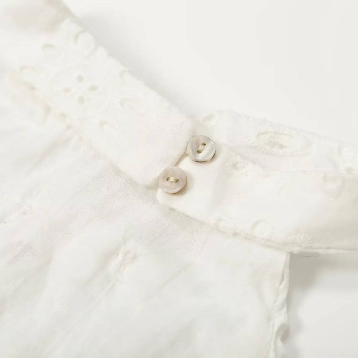 Close-up of mother of pearl buttons at back of halter neckline