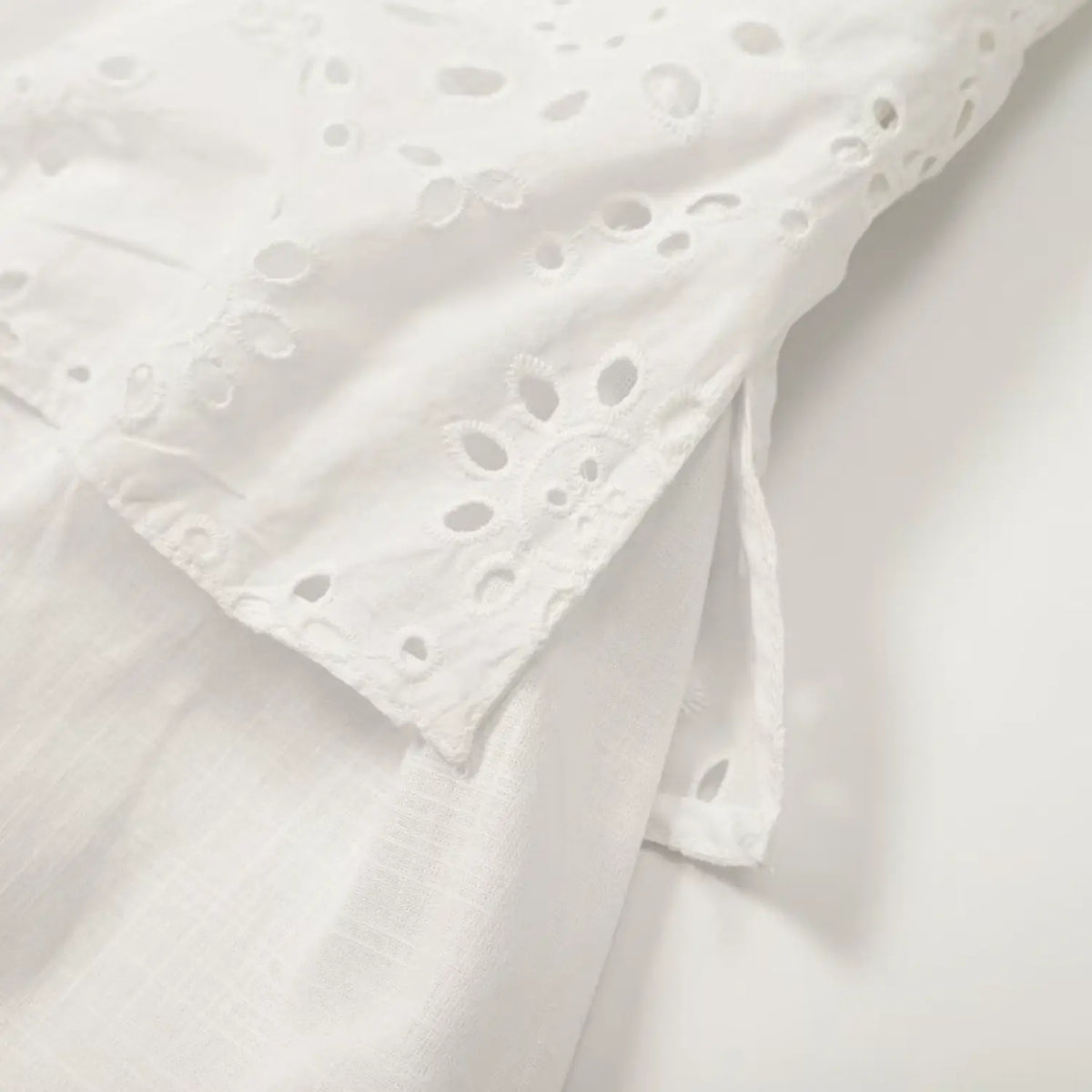 Close-up of embroidered bodice joining flowy white skirt
