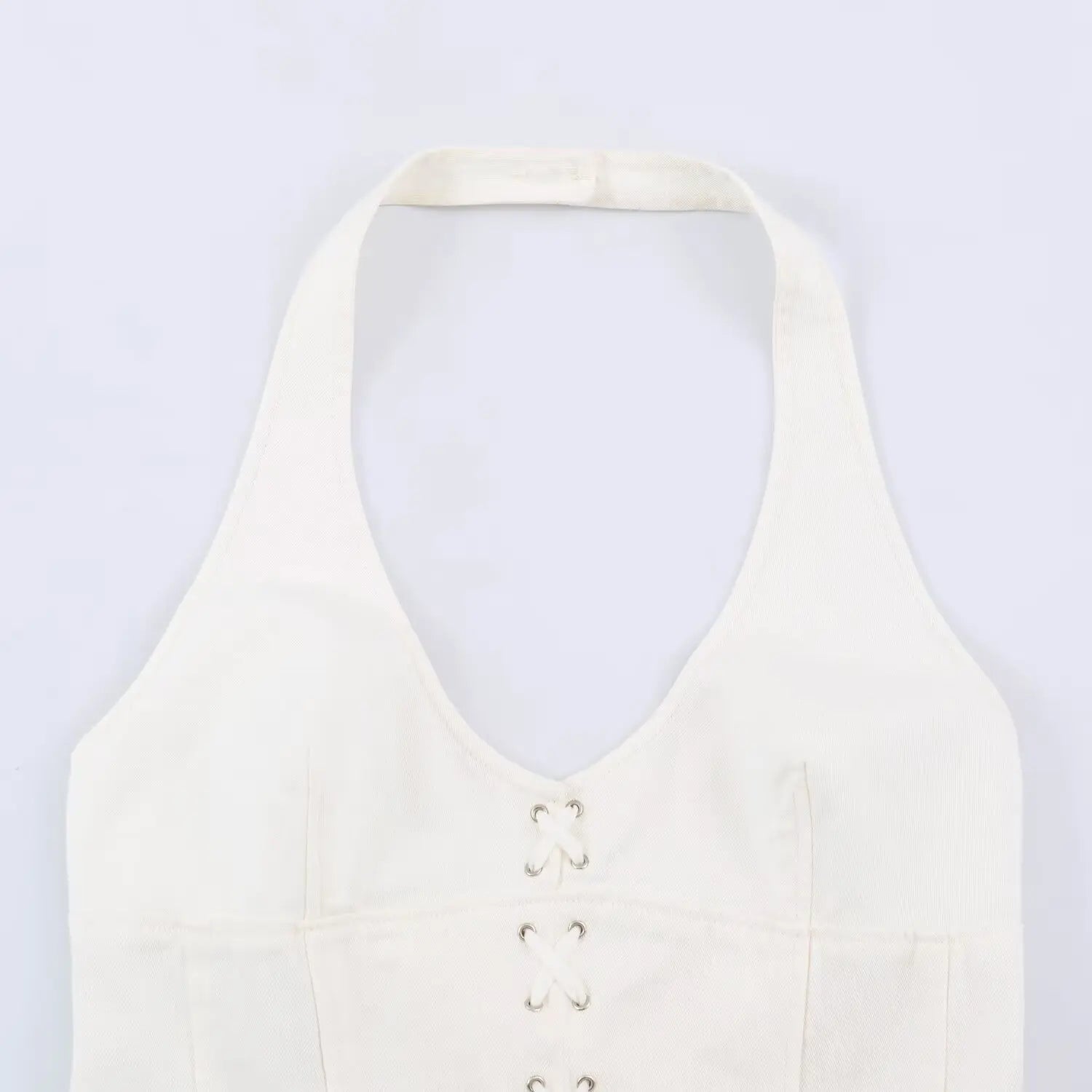Close up of halter v neck and front eyelet lace up corset stitching on white mini dress