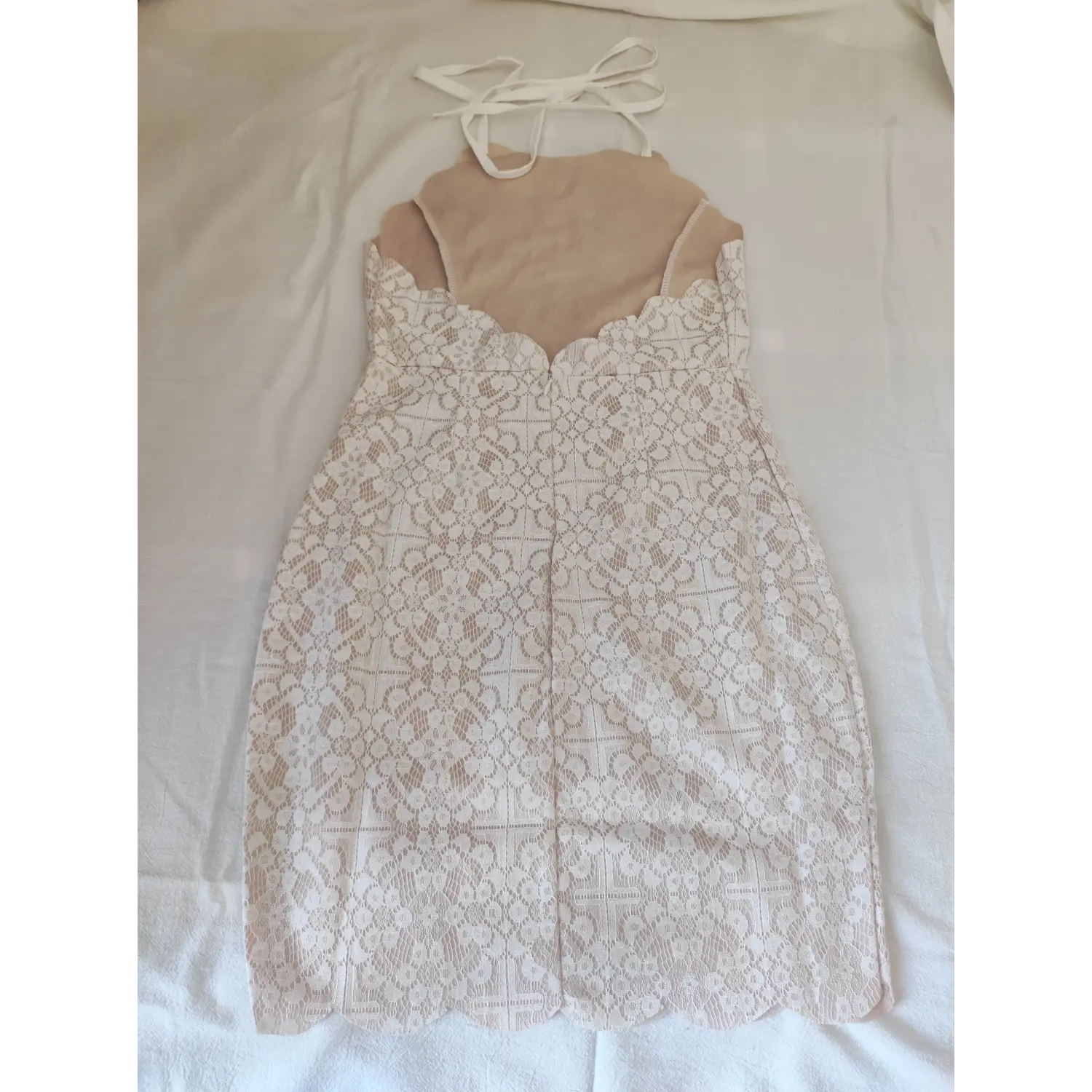 Flat lay back view, halter tie back white lace dress, scalloped v-back and invisible zipper