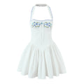 Front view on white background, white halter fit-and-flare mini dress with blue floral embroidery, scalloped blue edge trim and front bust tie bow