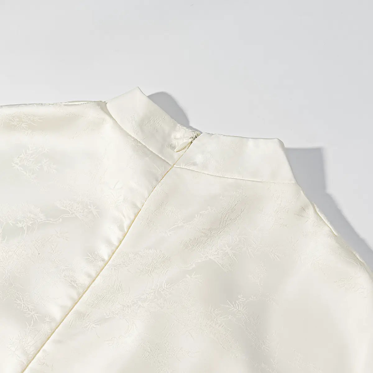 Back neckline detail of white cheongsam dress, showing the invisible zipper and mandarin collar