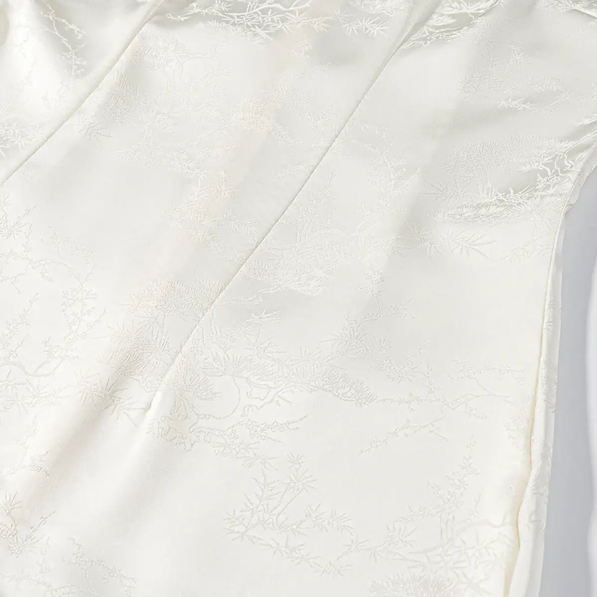 Close-up of the bamboo and pine jacquard pattern on the white cheongsam dress fabric