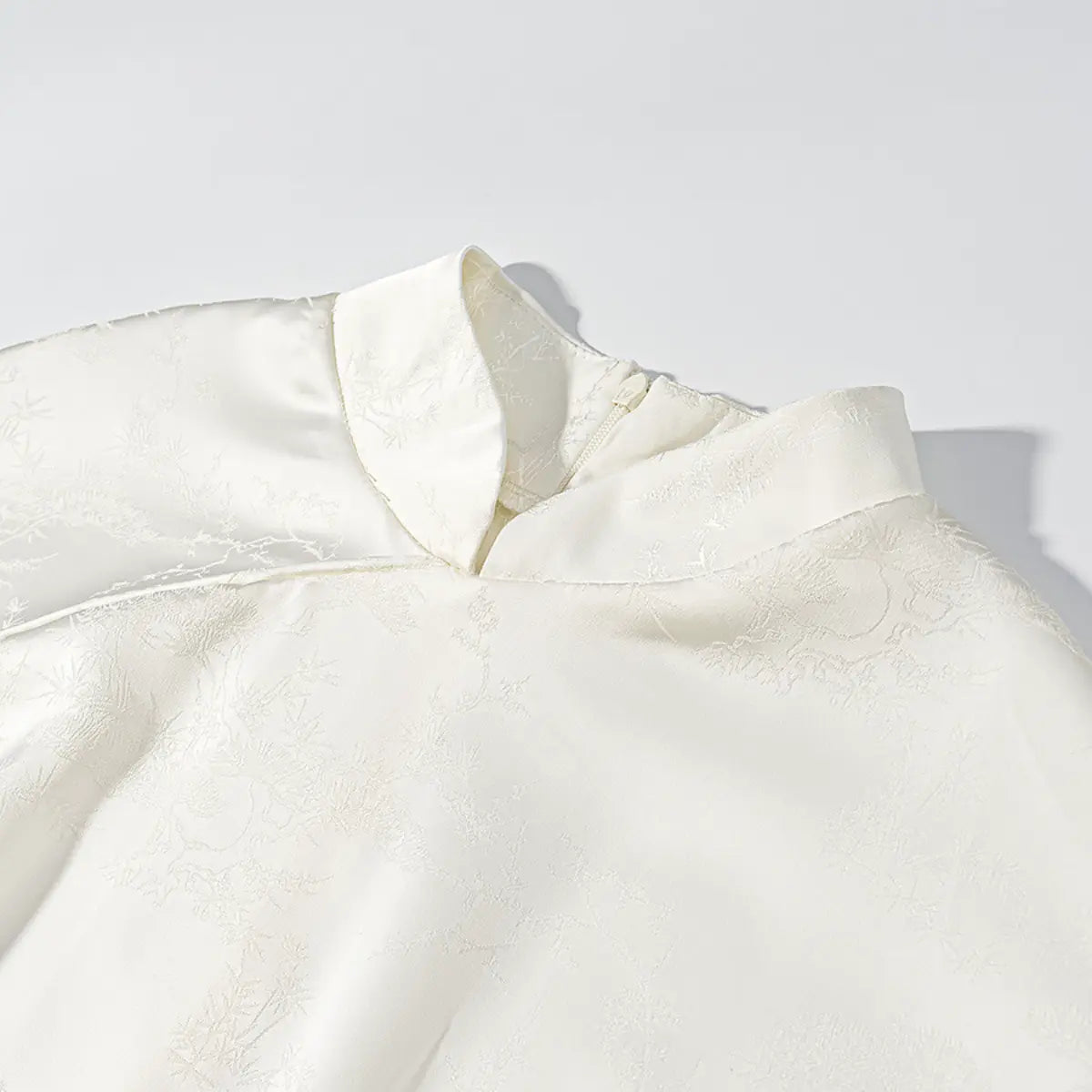 Front collar detail of white cheongsam dress, showing the mandarin collar and placket