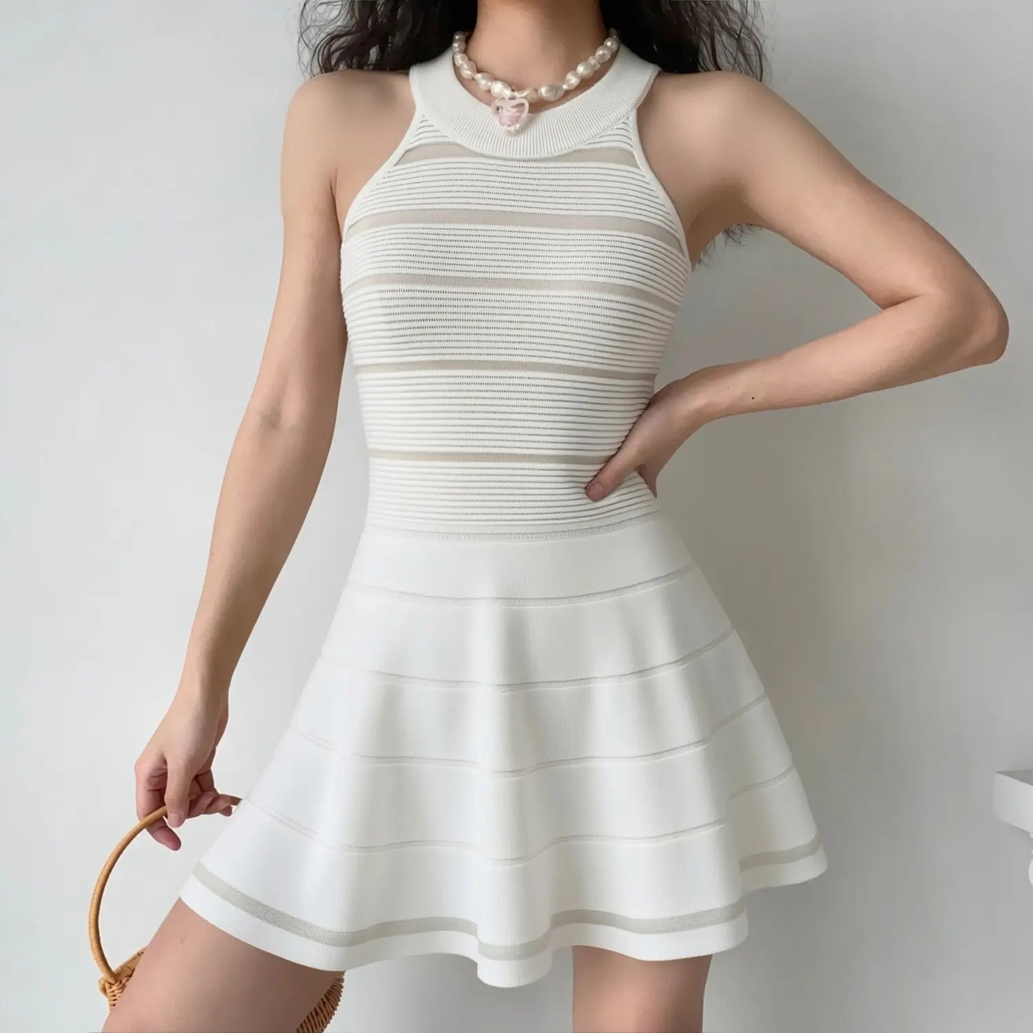 White halter knit dress natural light half body wearing shot, sunlight highlight sheer stripe texture halter neck flatter collarbone waist shaping match rattan bag soft date outfit display