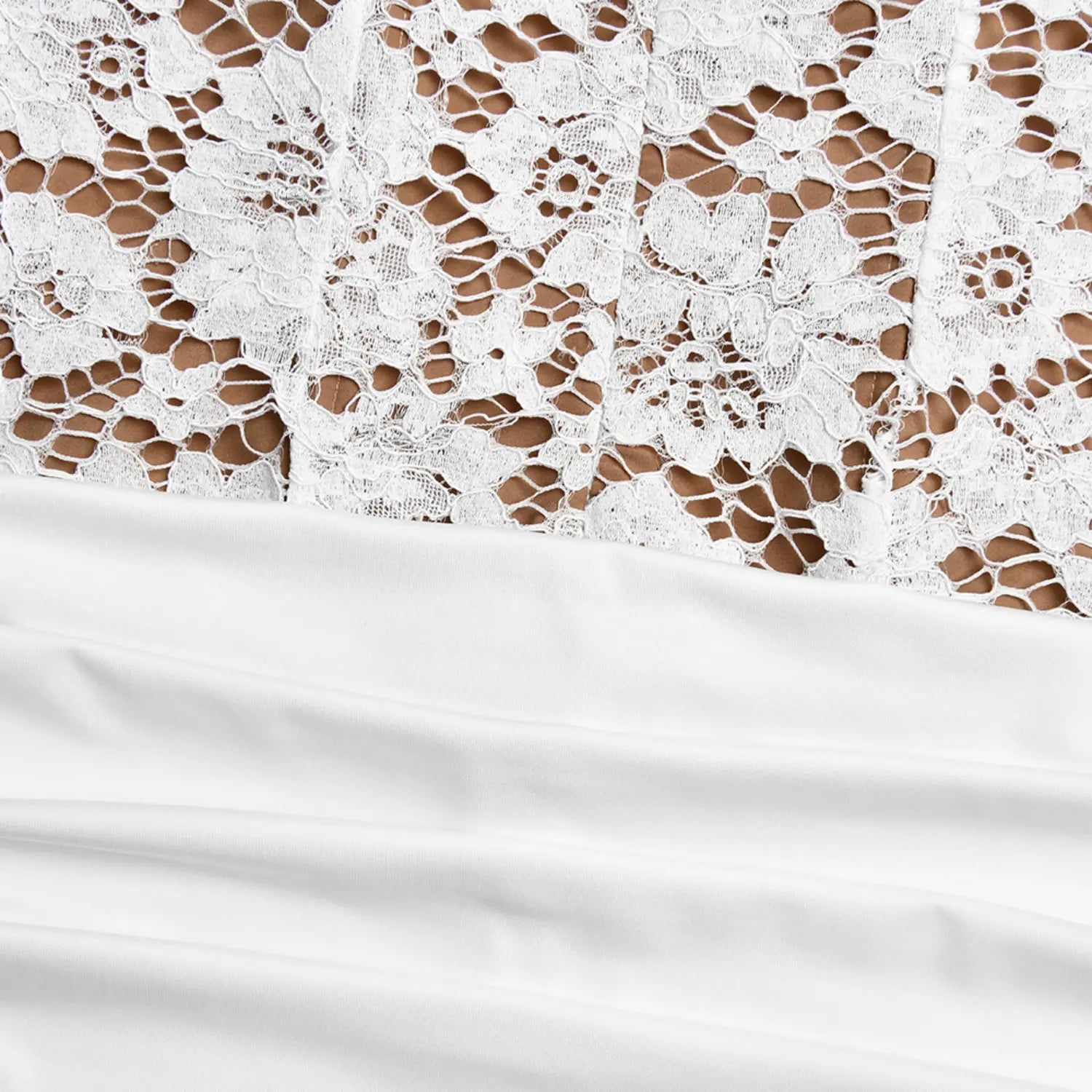 Close‑up transition detail between white floral lace bodice and ruched stretch skirt
