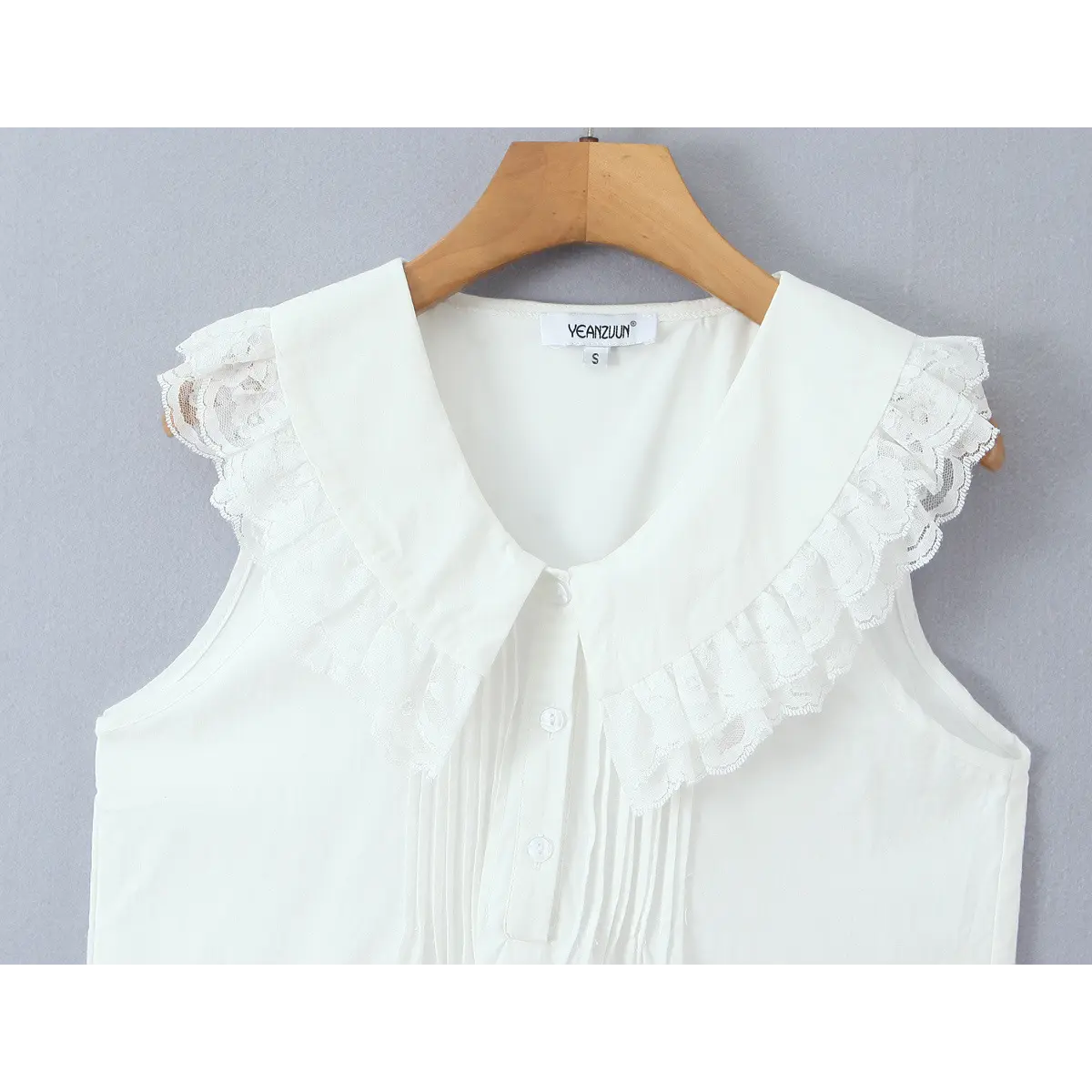 Close-up of the lace-trimmed Peter Pan collar, front buttons, and pintuck pleats.