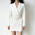 Model wearing white long sleeve blazer mini dress, notched lapel, floral lace corset waist with side pockets