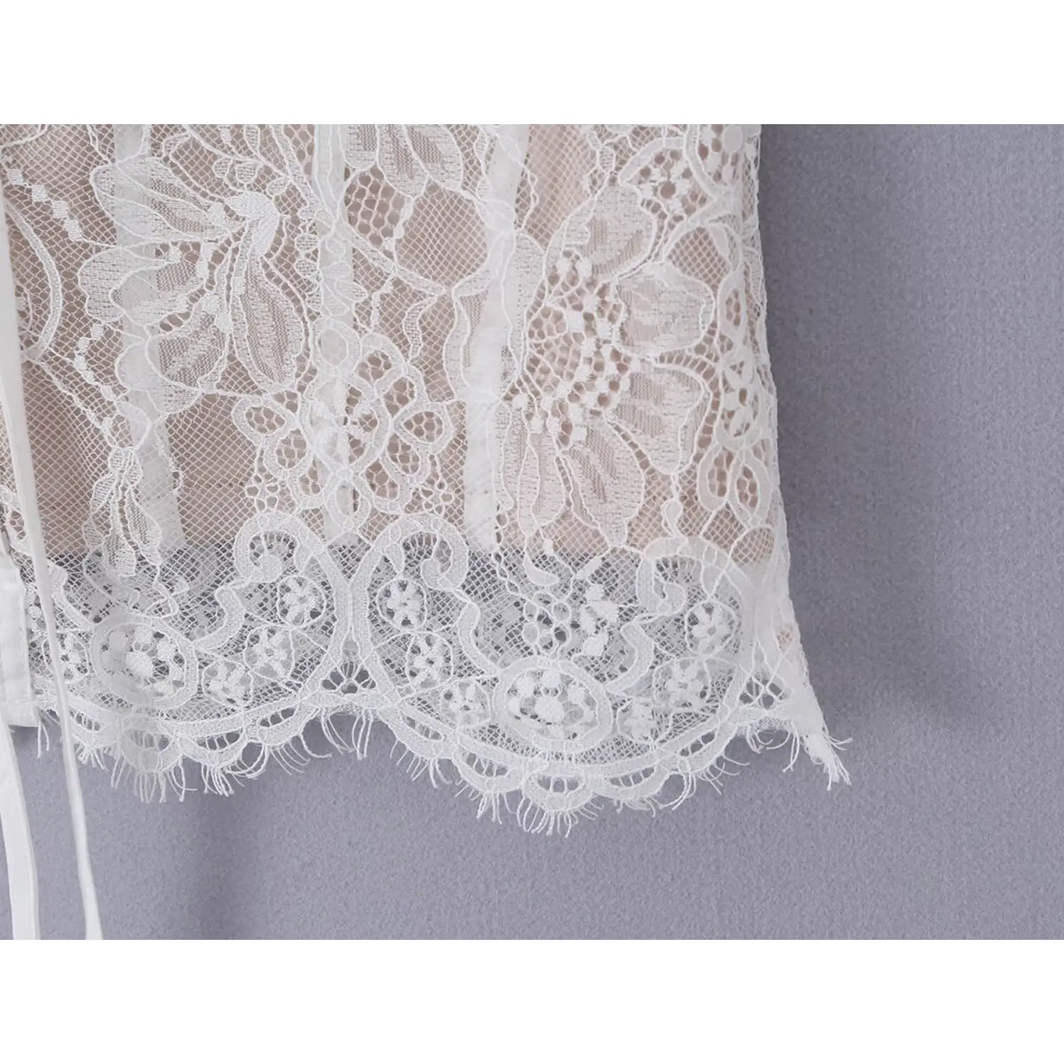 Close‑up detail of bottom scalloped eyelash lace hem pattern