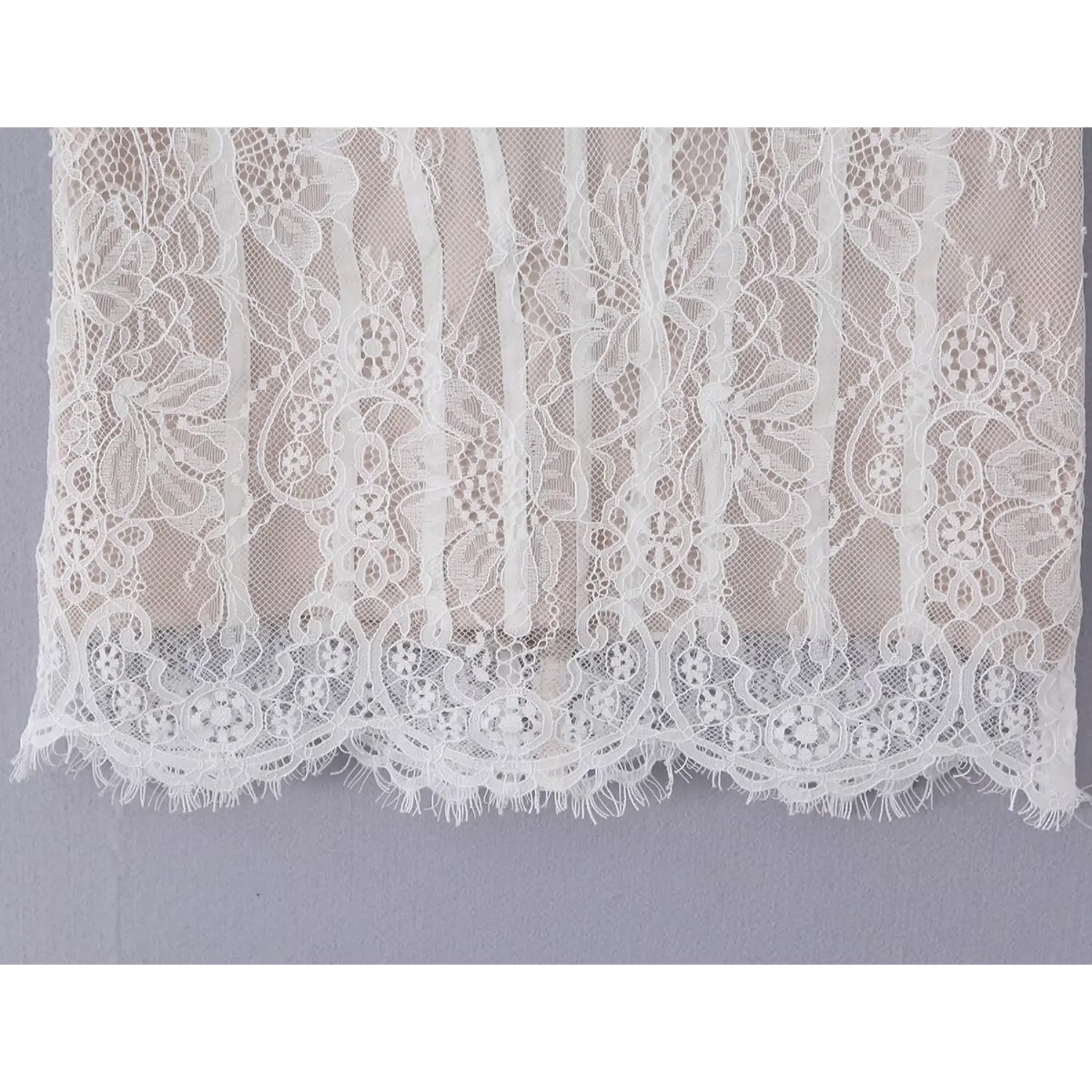 Close‑up shot of scalloped fringe lace hem embroidery detail