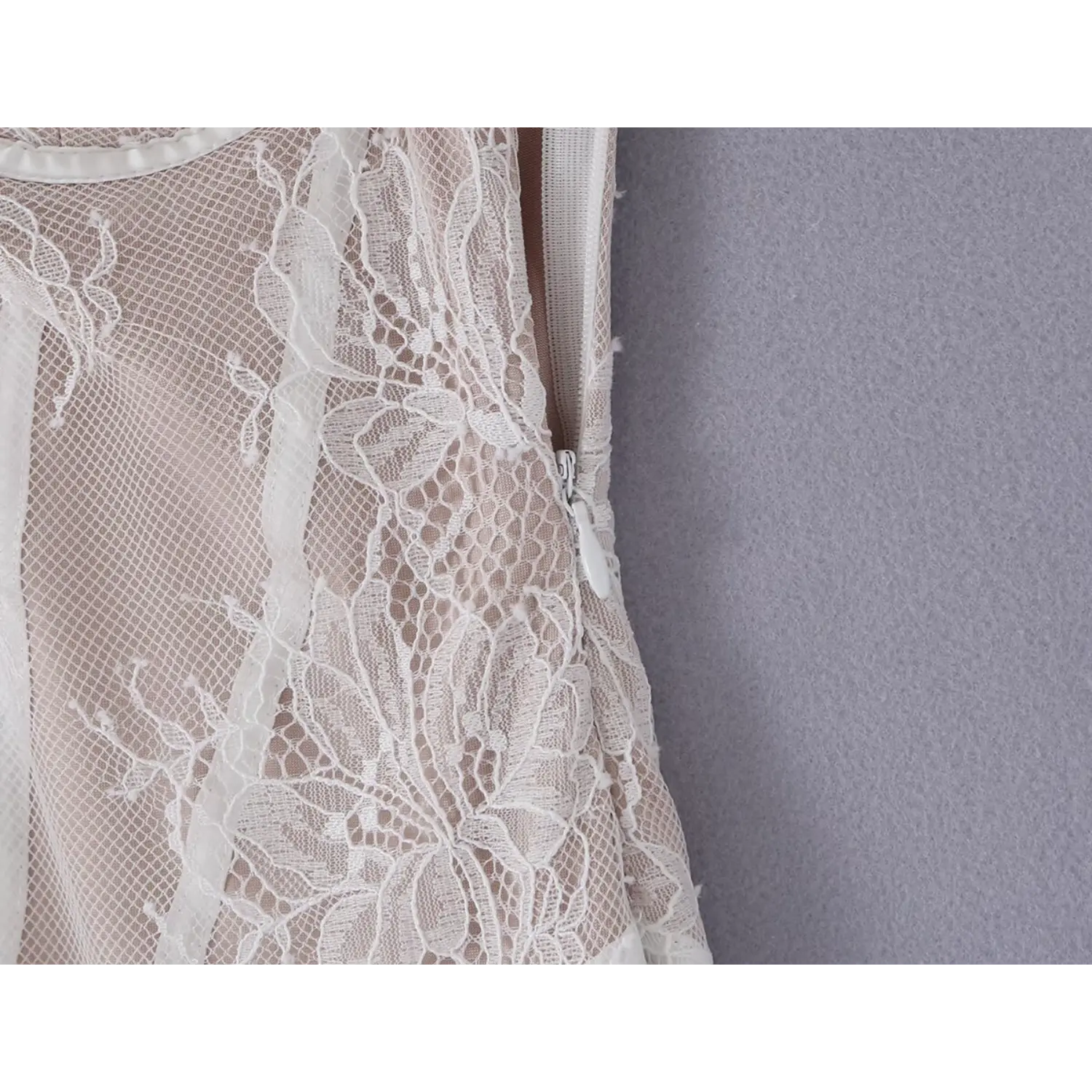 Close‑up side view of hidden invisible zipper on white lace corset dress